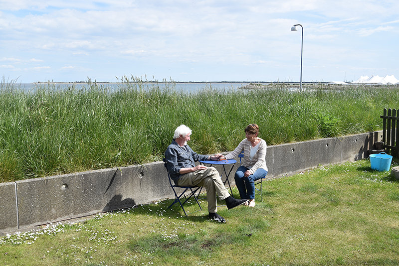 Inge og Christian Poulsen i haven, der er beskyttet af diget i Nordby.
