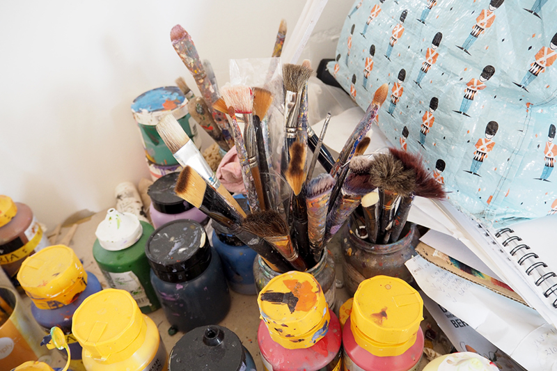 Pensler og bøtter med maling står i pæn orden i atelieret.
