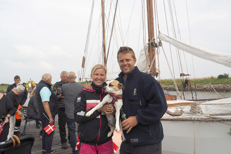 Louise Petersen og Rasmus Sonnichsen blev modtaget af venner og familie med flag og øl på havnen i Nordby. De havde hunden Pippi med hjem, som de havde fundet på gaden på Saint Martin.