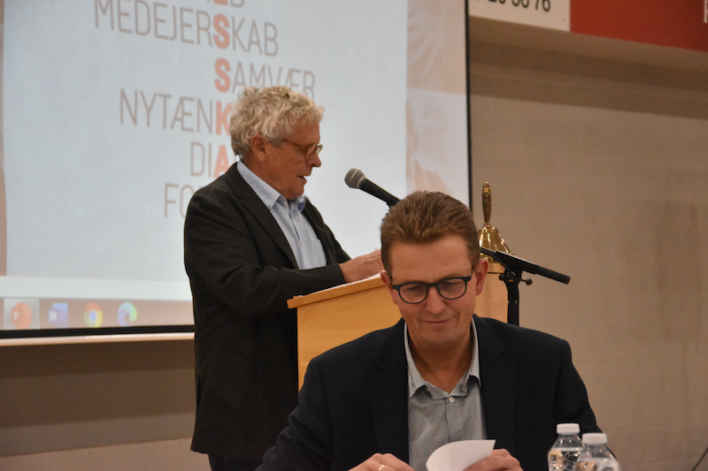Formand Hans Mathiasen på talerstolen. Foran ham ses brugsuddeler Bent Kruse Madsen.