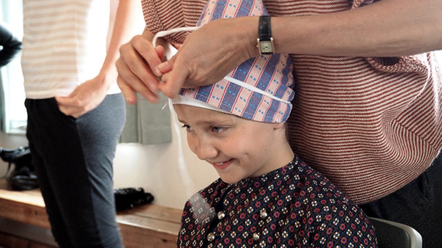 Formanden for Fonden Gamle Sønderho, Susanne Winsløw, hjælper Ronja Thomsen Østerlund med tørklædet. Ronja er 11 år og bor i Hadsten. Hun kommer i Sønderho, fordi hendes mormor har sommerhus i byen.